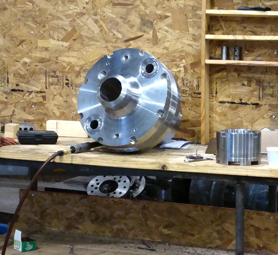 large machined part sitting on shop table in process of testing for quality work